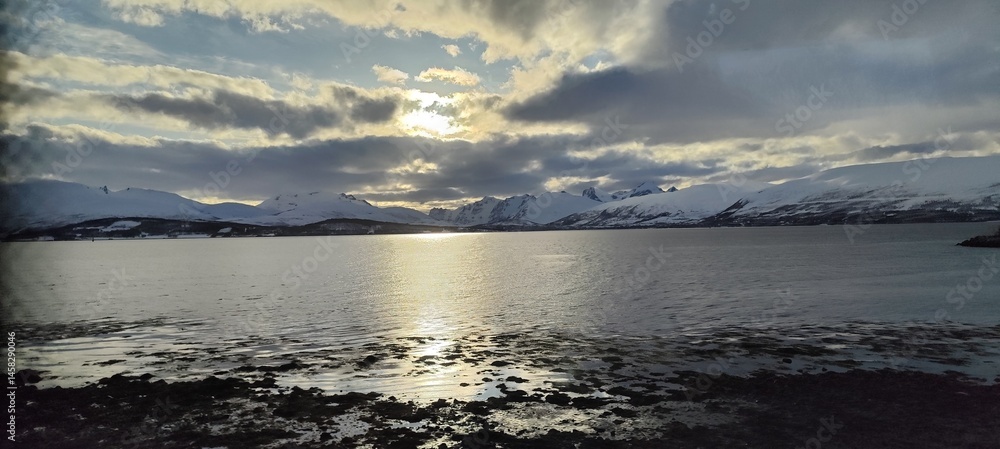 Obraz premium Gorgeous picture of the sunset over the fjords in Tromsø, Norway, during a lovely spring evening.