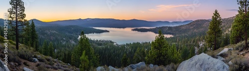 Obraz na płótnie Panoramic view of a serene lake nestled in a mountain valley at dawn. w salonie