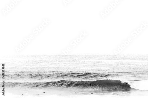 Large black and white wave breaks with one surfer in the water