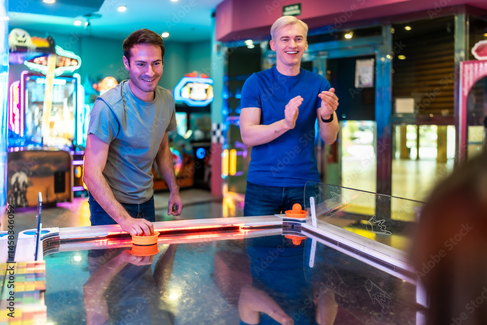 Friends playing air hockey in entertainment center