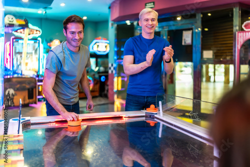 Obraz na płótnie Friends playing air hockey in entertainment center w salonie