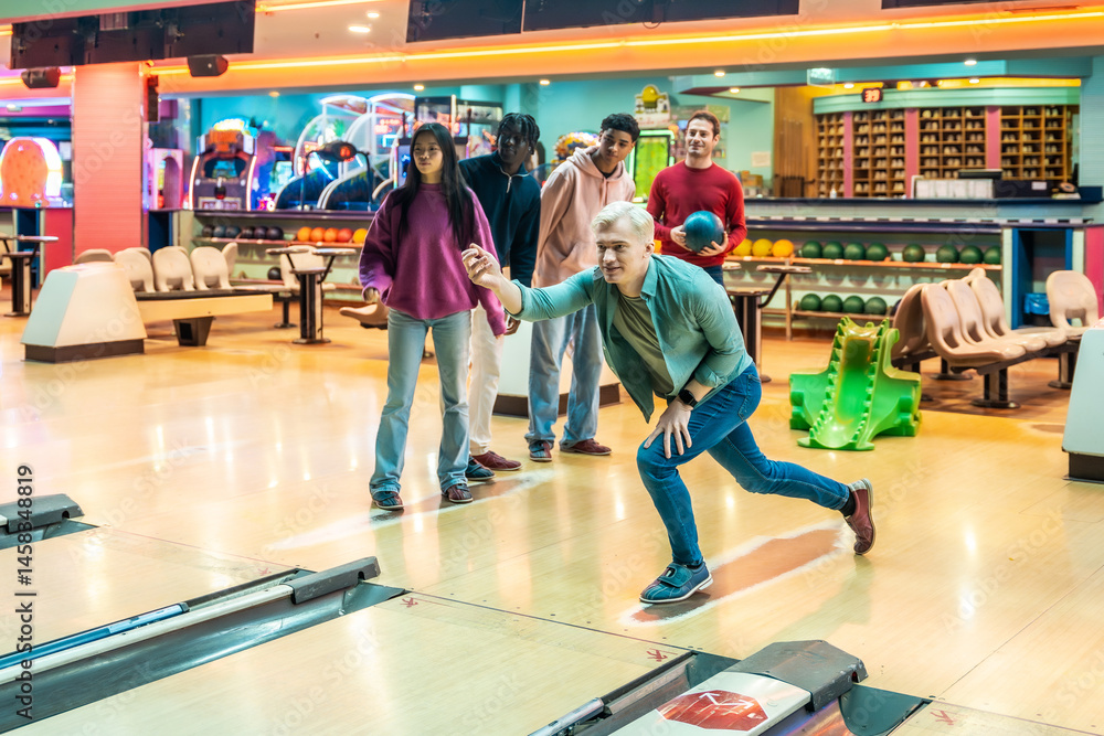 Group of friends playing bowling together in a bowling alley