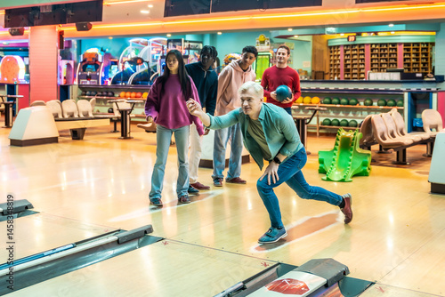 Obraz na płótnie Group of friends playing bowling together in a bowling alley w salonie