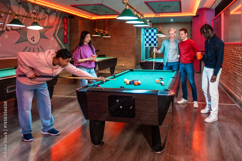 Young people playing billiards in entertainment venue
