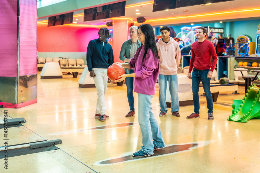 Young woman bowling with friends at a bowling alley