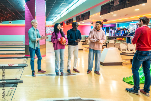 Obraz na płótnie Young multiethnic friends enjoying bowling together at the bowling alley w salonie