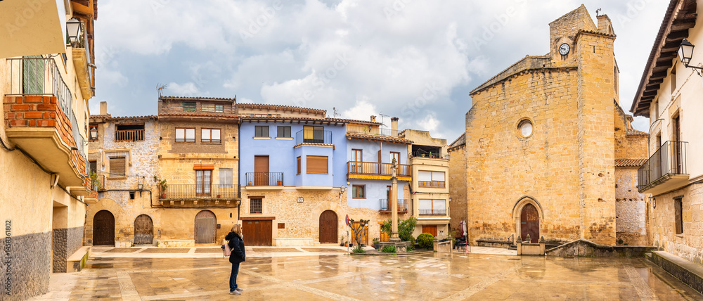 Tourist woman contemplating the main square of the medieval town of Rafales, Teruel, Aragon.