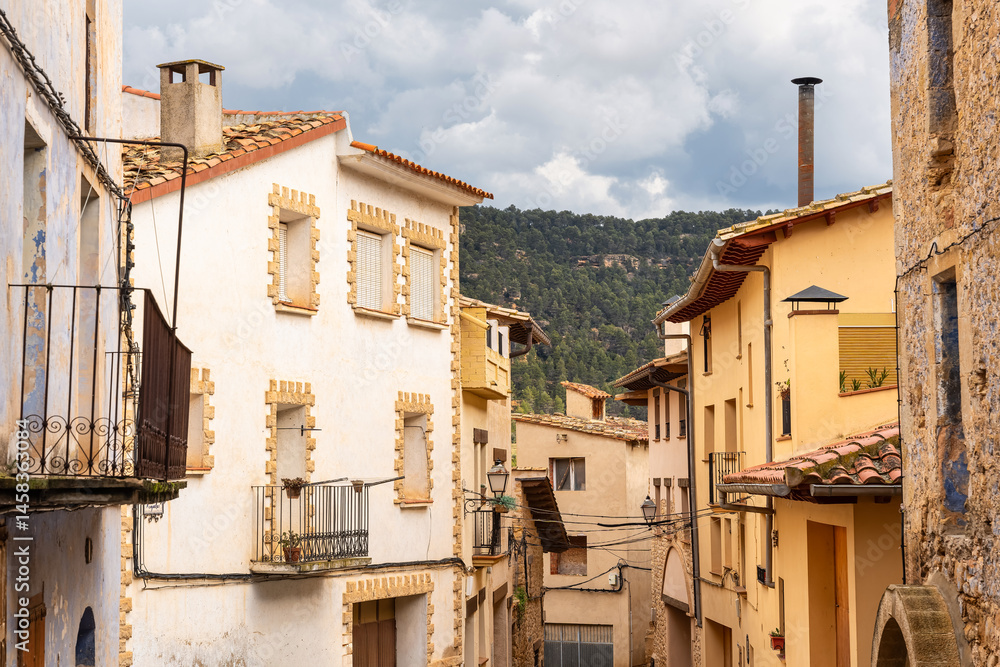 Picturesque alley with old stone houses in the medieval village of Rafales, Teruel, Spain.