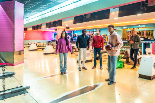 Obraz na płótnie Young multiethnic friends enjoying bowling together at a colorful alley w salonie
