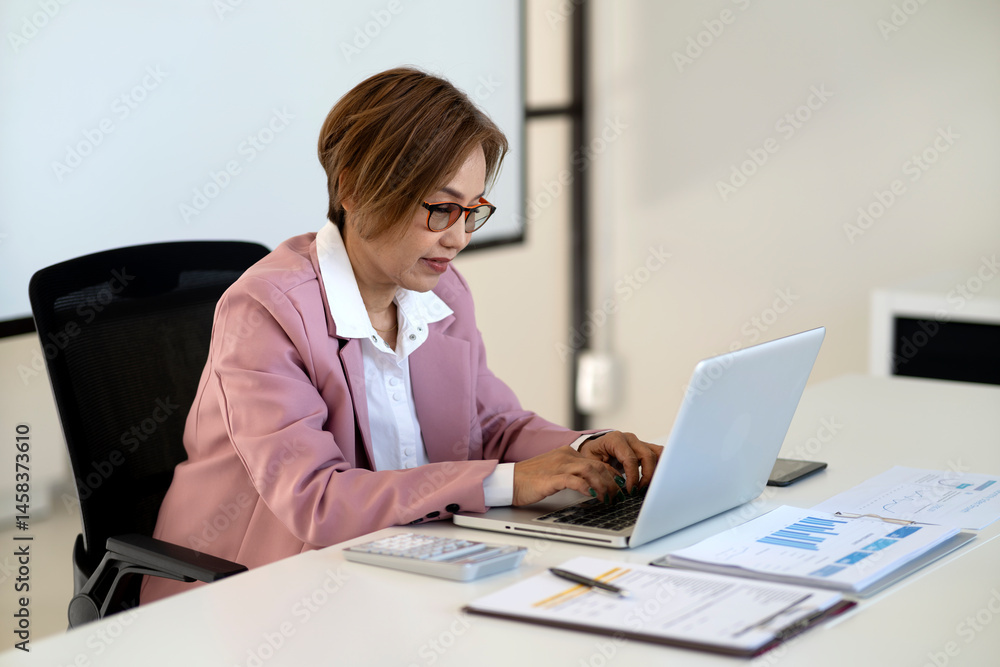 Business woman 50+ years old executive level typing on a laptop keyboard Business woman 50+ years old executive level typing on a laptop keyboard
