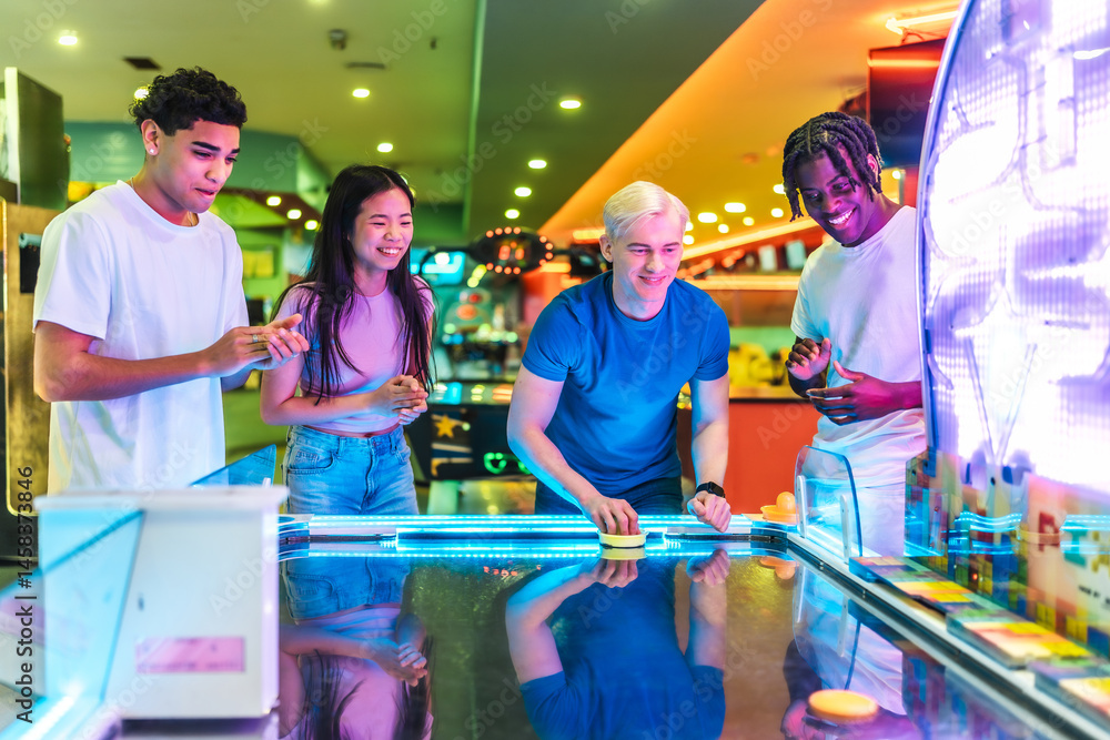 Young people playing air hockey in an amusement arcade