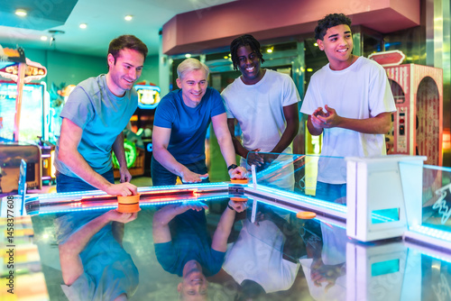 Obraz na płótnie Friends playing air hockey in entertainment center w salonie