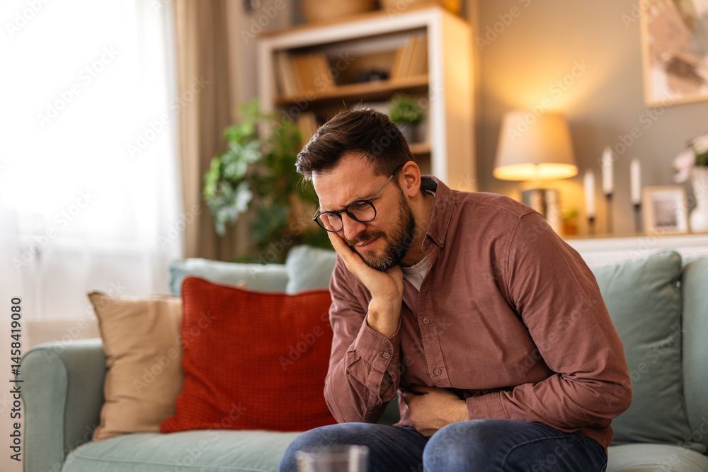 Man touching his cheek with a pained expression, experiencing sharp tooth pain. Dental problems such as cavities, sensitivity, or infection. Suitable for healthcare, dentistry, and insurance concepts Man touching his cheek with a pained expression, experiencing sharp tooth pain. Dental problems such as cavities, sensitivity, or infection. Suitable for healthcare, dentistry, and insurance concepts