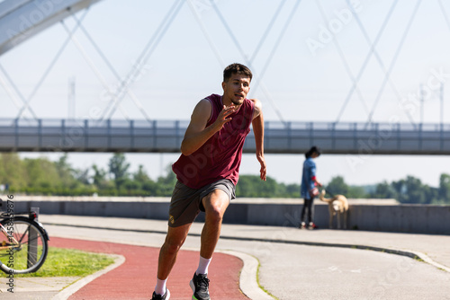 Young man runs on a trim track in the city