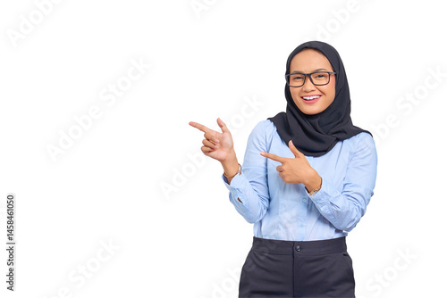 Portrait of smiling young Asian woman pointing finger at copy space isolated on transparent background