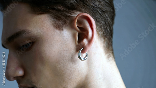 Detailed View of a Mans Ear with Silver Earring and Hair Detail