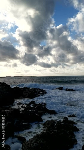 Wallpaper Mural Sea rocks clouds. Vertical atmospheric landscape with a seashore. The bright sun illuminates the beach through the clouds. Sideways movement of the camera. Panoramic view of the summer sea coast Torontodigital.ca