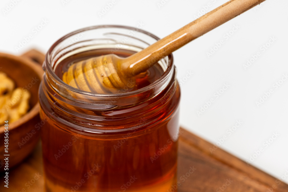 Close up shot of honey dipper immersed in a jar of honey Close up shot of honey dipper immersed in a jar of honey