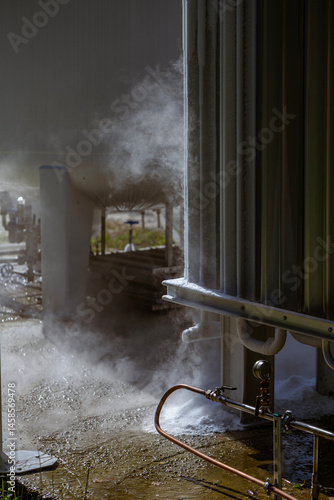 Obraz na płótnie An oxygen station that produces and supplies medical oxygen to a hospital. The station includes radiators and a large white cylinder containing liquefied oxygen for distribution. w salonie