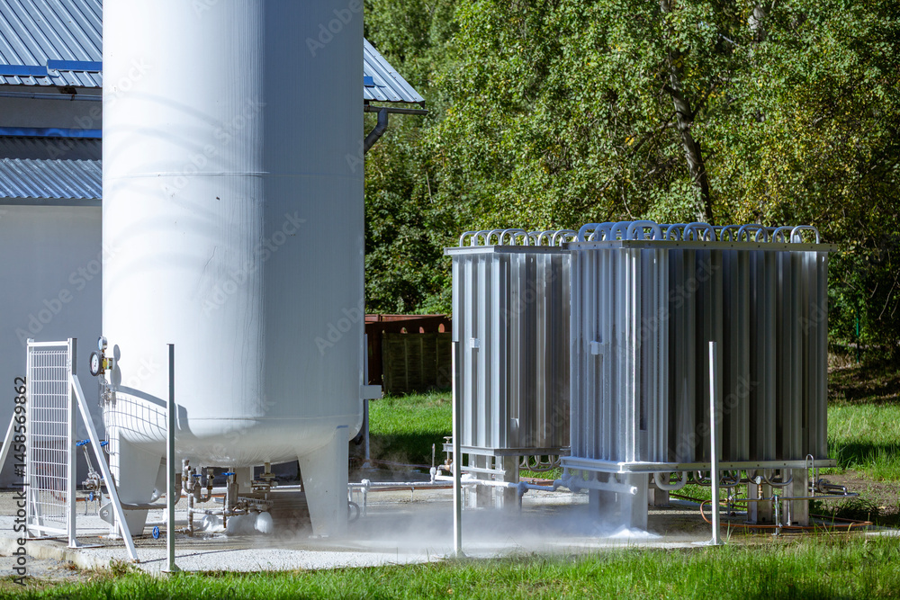 Fototapeta premium An oxygen station that produces and supplies medical oxygen to a hospital. The station includes radiators and a large white cylinder containing liquefied oxygen for distribution.