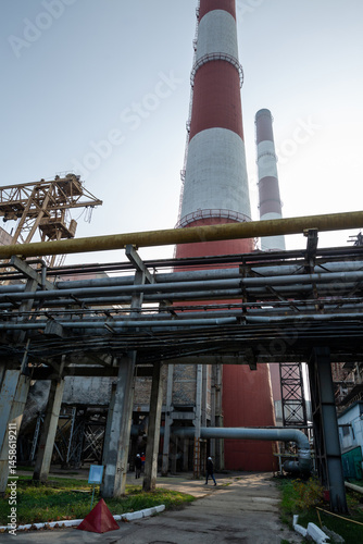 Obraz na płótnie A massive gas exhaust system at a high-capacity thermal power plant. Towering red-and-white chimneys exceed 150 meters in height, facilitating emissions management and industrial air circulation. w salonie