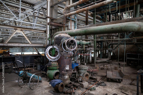 Obraz na płótnie Disassembled industrial valve undergoing maintenance and repair. The metal casing, bolts, internal components are arranged on a workbench, showing detailed mechanical parts and structured engineering w salonie