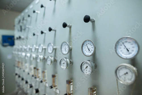Obraz na płótnie Control panel with multiple pressure gauges and adjustment knobs used for regulating fluid or gas pressure in an industrial system. The gauges display various pressure levels w salonie