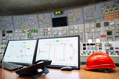 Obraz na płótnie Control room for monitoring and managing industrial operations, with various control panels, analog and digital displays, buttons, and switches. A computer monitor displays graphs and data. w salonie