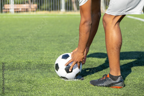 Soccer player placing ball on artificial turf field