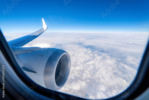 Airplane engine and wing seen from the window. Flying in an airplane above the clouds.