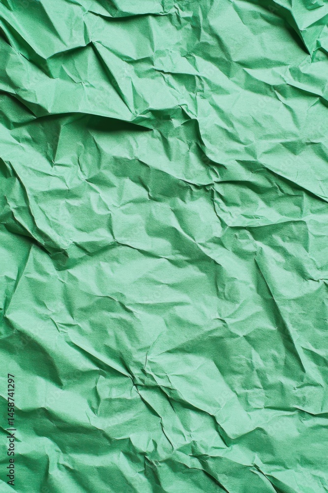 Fototapeta premium Textured green paper creates an interesting background for artistic projects or crafting