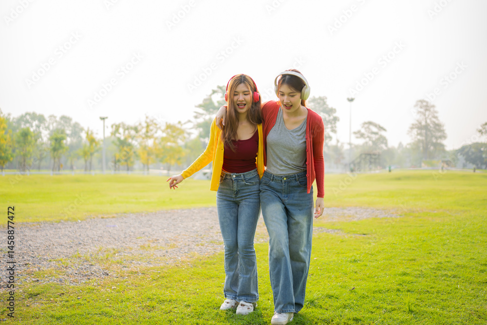 Fototapeta premium Happy Asian woman listening to music outdoors