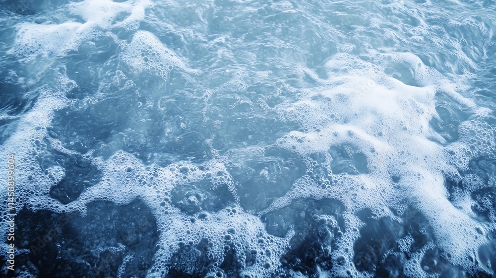 Obraz premium Close-up view of ocean water with white foam and bubbles, creating a textured surface with shades of blue and grey. The image evokes a sense of calmness and serenity. : Generative AI