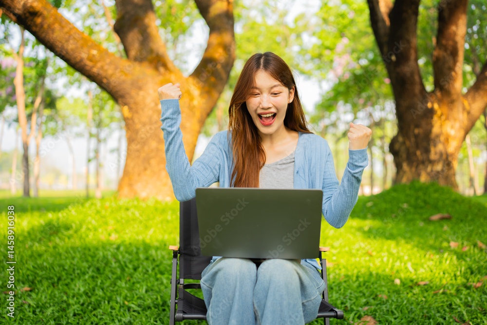 Young Asian woman using laptop to work online in nature Young Asian woman using laptop to work online in nature
