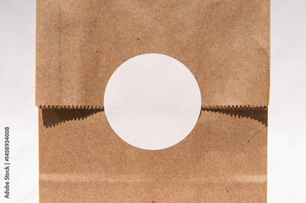 Blank circular sticker on brown paper bag for custom design