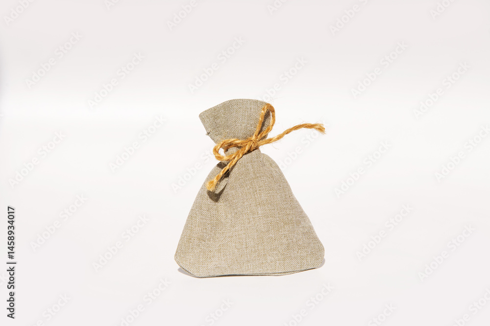 Simple beige burlap sack with twine against plain background