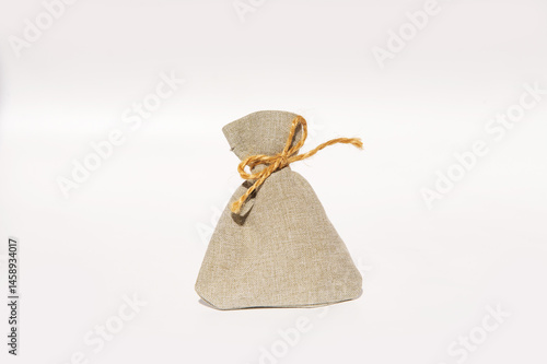 Obraz na płótnie Simple beige burlap sack with twine against plain background w salonie