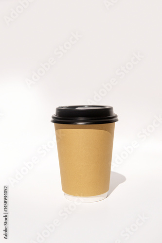 Obraz na płótnie Brown paper coffee cup with black lid on light background w salonie