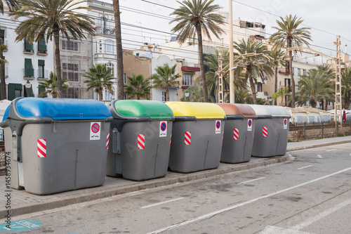Colorful recycling bins in urban setting with palm trees