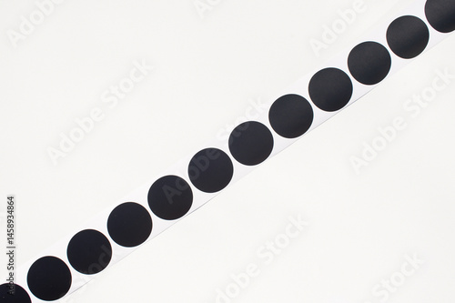 Obraz na płótnie Black circle stickers on a roll against white background w salonie