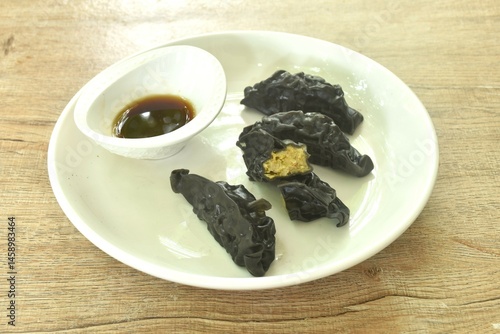 Obraz na płótnie steamed black squid ink Gyoza or Japanese dumpling stuffed mashed pork curry dipping shoyu sauce on plate w salonie