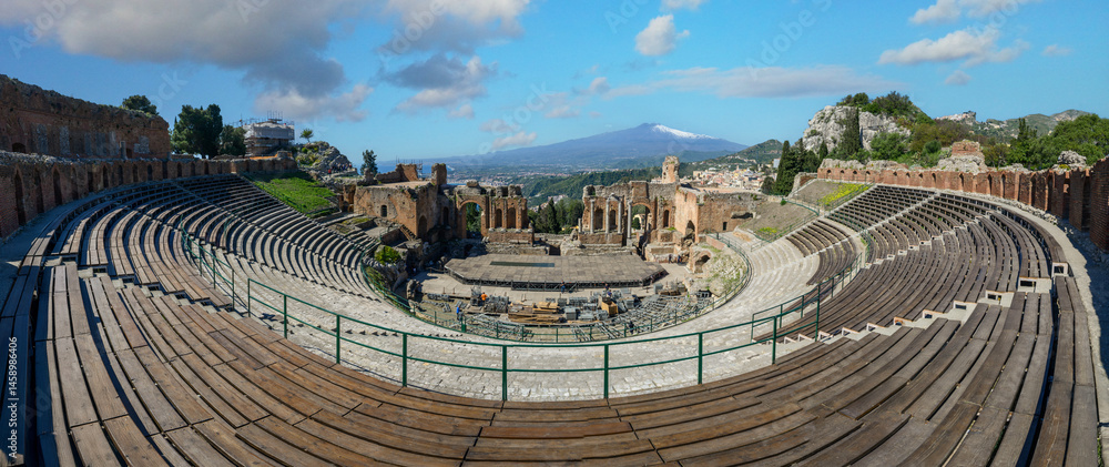 Naklejka premium Panoramic view of the Ancient theater of Taormina with Mount Etna in the background, Sicily, Italy