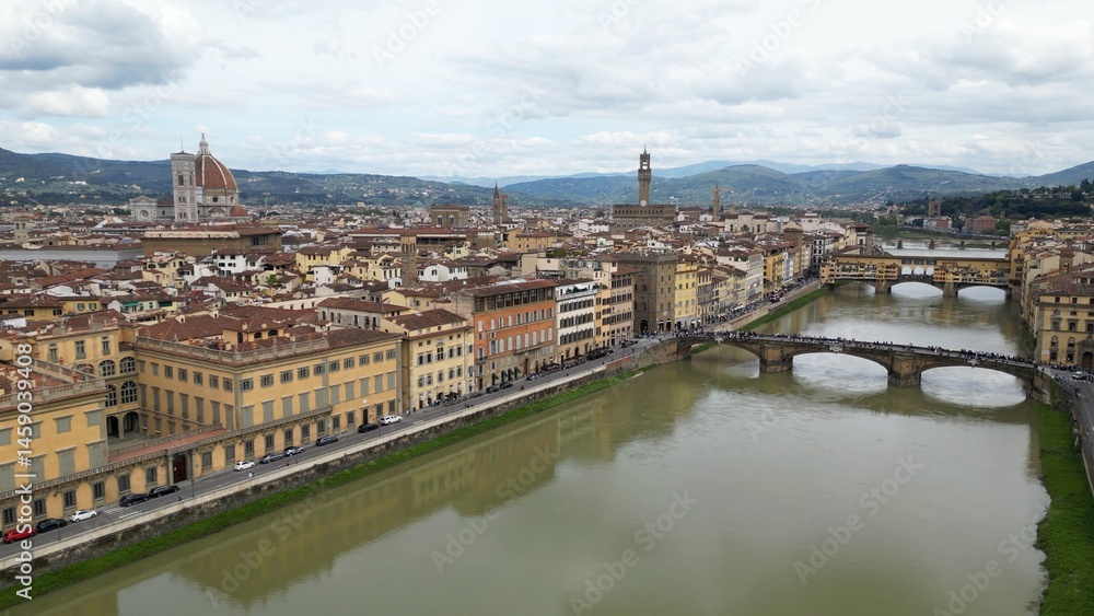 Fototapeta premium Europe, Italy, Florence , drone aerial view of Florence and Arno river - the Old Bridge , Ponte Vecchio , in city downtown of the Middle Ages and Renaissance art - Tourist attraction destination 