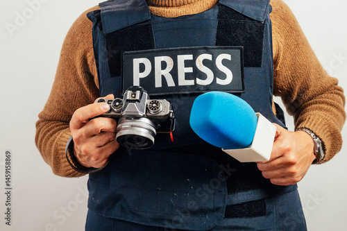 Cuadro en lienzo Reporter in bulletproof vest with a camera.