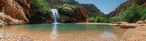 A captivating view of a waterfall cascading into a pool surrounded by stunning rock formations.