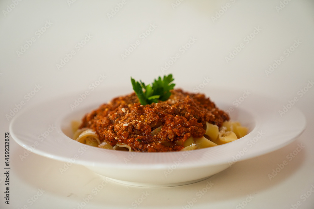 Top view of fettuccine pasta with tomato sauce, cheese and parsley on a white plate isolated on white background. Top view of fettuccine pasta with tomato sauce, cheese and parsley on a white plate isolated on white background.