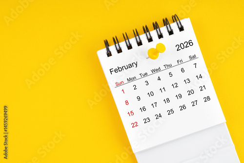 February 2026 Monthly desk calendar for 2026 year with thumbtack on yellow background.
