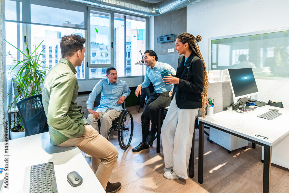 Diverse business team collaborating in modern office with disabled colleague