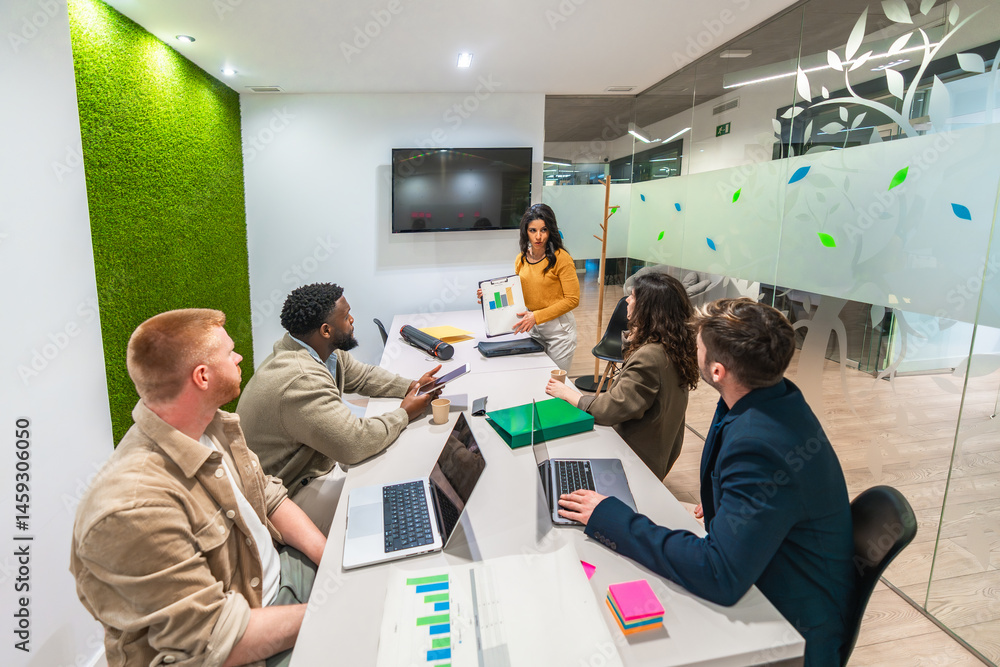 Marketing team analyzing charts during business meeting in modern office