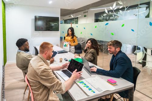 Marketing managers working on strategy with charts and laptop in meeting room